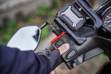 Person wearing gloves holding motorcycle handle.