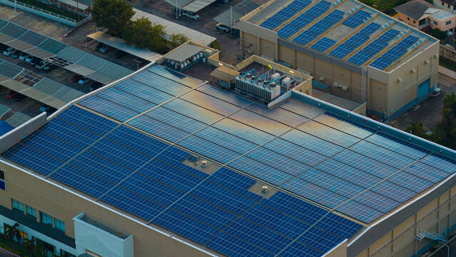 Solar roof, Solar on the roof, top view worker installing a solar cell on the factory roof, panels on tin roof seen from aerial view, panesl power.