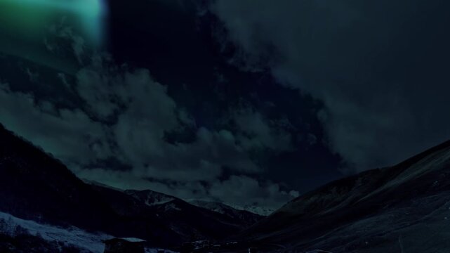 Faint northern lights above clouded valley, dark silhouettes of ridges and distant peaks under brooding sky, cinematic mood suitable for atmospheric storytelling and timelapse projects