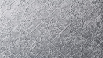 Elegant silver textured surface with intricate embossed geometric Arabic pattern