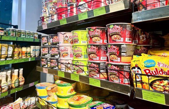 Jakarta, Indonesia - February 25th, 2026 - Samyang buldak instant noodle and mayonnaise bottle sauces grocery isolated on horizontal store shelf background.