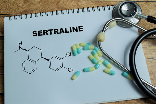 Concept of sertraline antidepressant medication write on book isolated on Wooden Table. SSRI treatment for mental health awareness and mood disorders