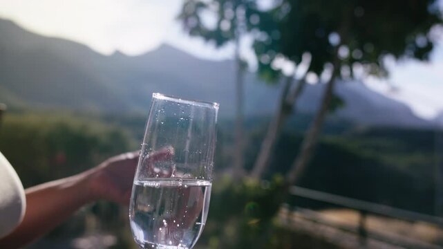 Young Woman Holding Sparkling Beverage and Enjoying Social Conversation in Nature at Dusk