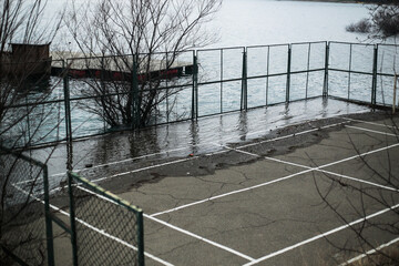 Flooded Parking Area Near Riverside Fence