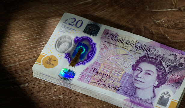 Stack of 20 GBP Notes on Wooden Table