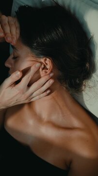 Woman receives careful chiropractic correction under studio lighting
