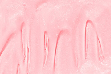 Fototapeta premium Smooth pink cosmetic cream texture with shimmering surface for skincare and beauty products.