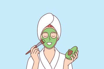 Young woman uses a green avocado face mask to hydrate her skin, treat acne, and improve her natural beauty. Concept of organic skin care, wellness routine, and healthy lifestyle choices.