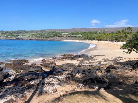 Rock pools in black lava along Hulopoʻe Beach on Lānaʻi Island, Hawaiʻi, with clear water, coastal views, and a tropical shoreline.
