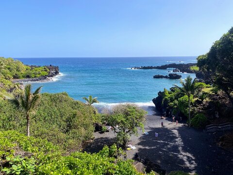 Visitors relax, swim, and take photos at paʻiloa black sand beach in waiʻānapanapa state park along maui&rsquo;s road to hana.
