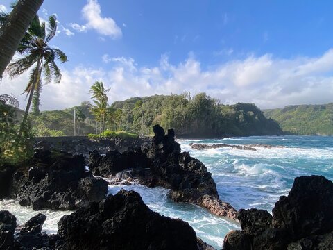 Winter scenes along the Road to Hana in Ke&lsquo;Anae, Maui, Hawaii. The images capture rugged black lava rock formations meeting the turquoise Pacific Ocean, framed by lush greenery and swaying palm trees 