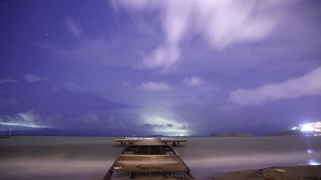 A ruined pier after a storm, and timelapse footage of stars and clouds in the sky. Lightning and thunder over islands in the Aegean Sea. A suitable video for meteor showers.