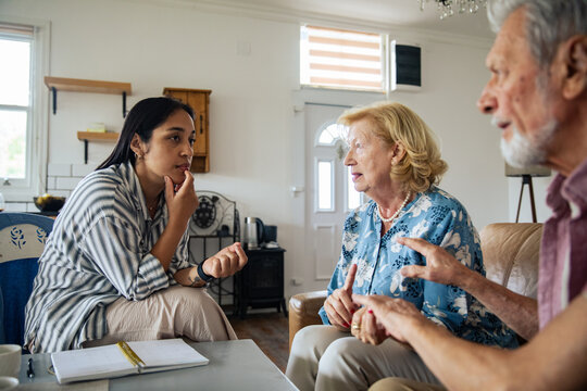 Social worker consulting with elderly couple at home