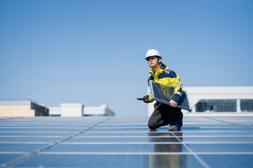 Solar engineer inspecting photovoltaic panels on a rooftop under clear blue sky
