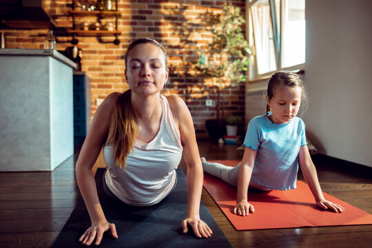 Mother and daughter practicing yoga at home