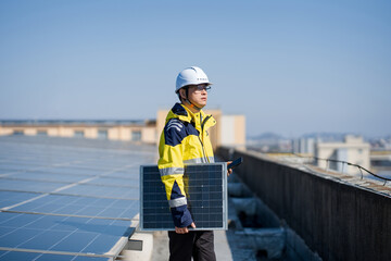 Engineer holding a solar panel while inspecting a rooftop photovoltaic power station