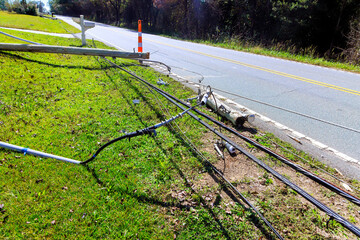Power lines are seen downed next to road in rural area, causing a disruption to local utilities...
