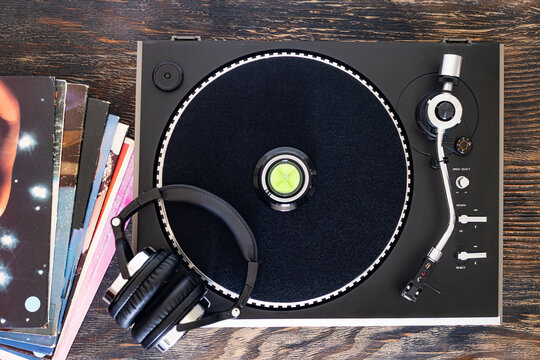 Analog turntable and vinyl records with headphones, music listening concept