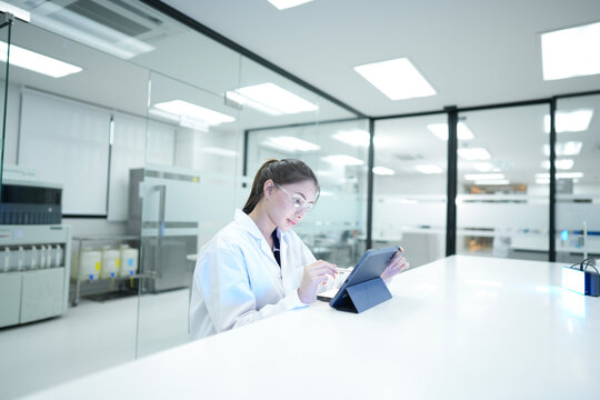 Biomedical researcher documenting microscopic validation results on electronic lab notebook. Quality control analyst auditing experimental data integrity via digital tool.