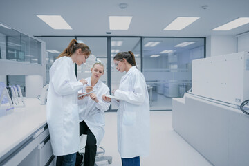 Obraz premium Senior academic mentor coaching graduate students on scientific methodology. University research group analyzing hypothesis validation metrics in advanced facility.