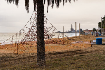 Rope climbing pyramid structure on an urban beach park.
