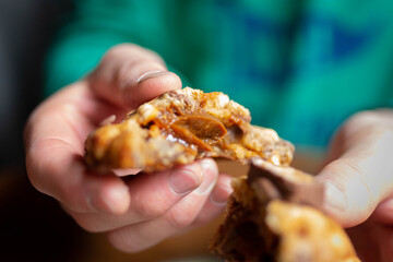 Hands breaking homemade caramel stuffed chocolate cookie