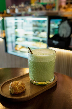 Matcha latte and scone served on wooden tray