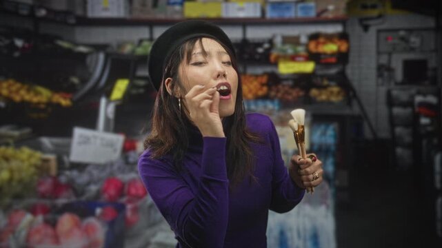 Woman holding makeup brushes while touching her mouth and squinting eyes among produce shelves in a building fruit market aisle; playful surprise.