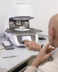 Obraz premium Orthodont programs dental ceramic oven for baking enamel of tooth implants. Dental prosthetics