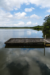 Fototapeta premium Lake of Soustons reflecting a cloudy sky and wooden docks