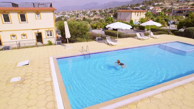 Female Tourist Swimming on Sunny Day in Beautiful Villa Outdoor Pool