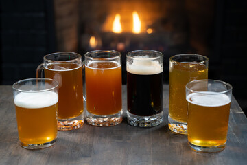 Assorted craft beer glasses on table with warm lights