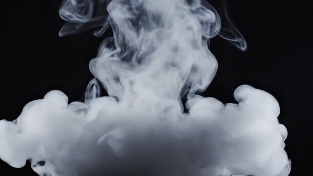 Thick white smoke billows and expands gracefully against a dark black background, creating