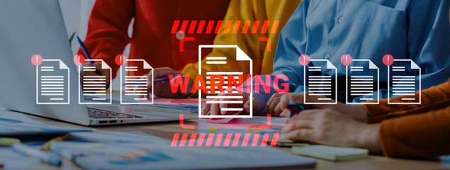 Professionals collaborate on a project while reviewing documents and a warning notice in a vibrant office setting, emphasizing teamwork and effective communication. Gantry