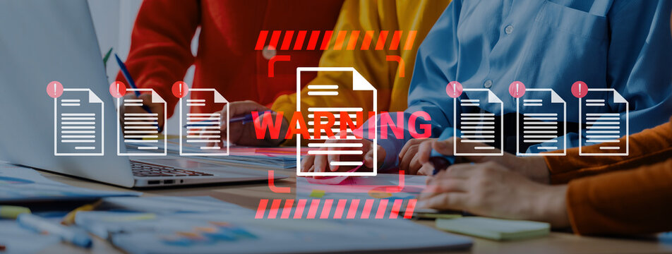 Professionals collaborate on a project while reviewing documents and a warning notice in a vibrant office setting, emphasizing teamwork and effective communication. Gantry