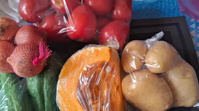 Fresh vegetables and fruits wrapped in plastic bags for sale
