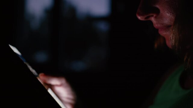 Close-Up of Woman Using Cellphone in Darkness with Hand Illuminated by Screen Glow