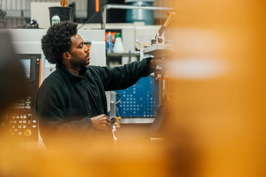 Male worker working on machine in production factory