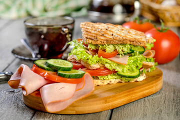 Sandwich with ham, cucumber, tomato and lettuce.