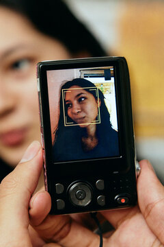 Close-up shot of person photographing woman through old digital camera