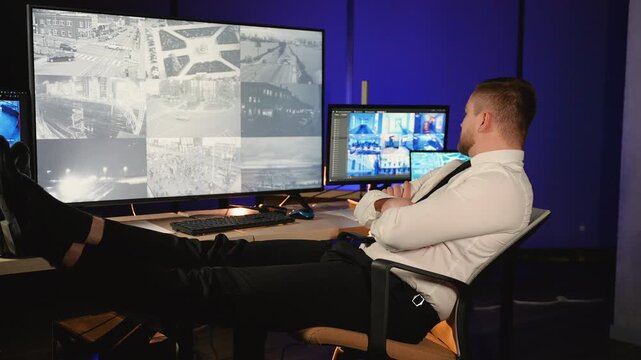 Security guard monitoring cctv camera footage in control room