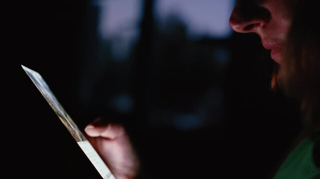 Detail Shot of Woman Browsing on Phone at Night Next to Window with Dim Lighting