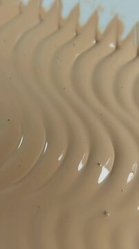 The art of smoothing cream in a zig-zag pattern. Close up of a beauty product. Vertical shot.