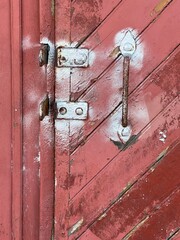 A metal handle on a red door