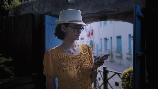 Tourist Female Sending Messages on Smartphone While Enjoying Cozy European Architecture