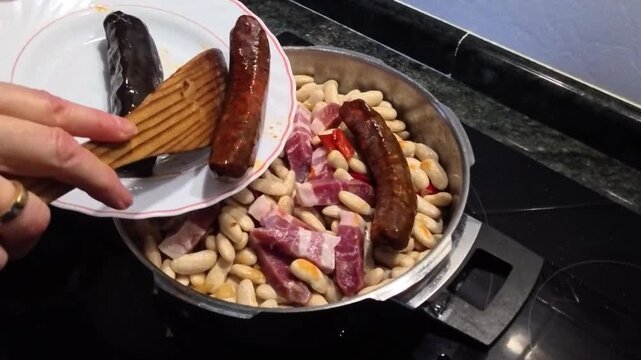 Chef preparing spanish fabada asturiana bean stew
