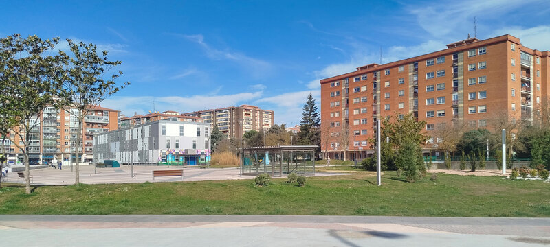 Vista panor&aacute;mica de un barrio residencial con zona verde y edificios de ladrillo bajo un cielo azul en Burgos, Espa&ntilde;a