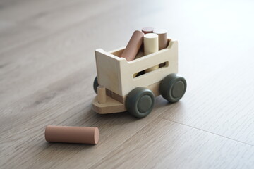 Wooden children's toy. Cart with logs.