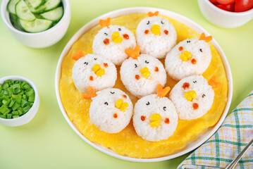 Rice ball onigiri with filling in the form of chicken with funny faces in a plate
