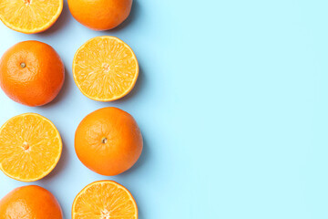 Fototapeta premium Fresh ripe tangerines on light blue background, flat lay. Space for text